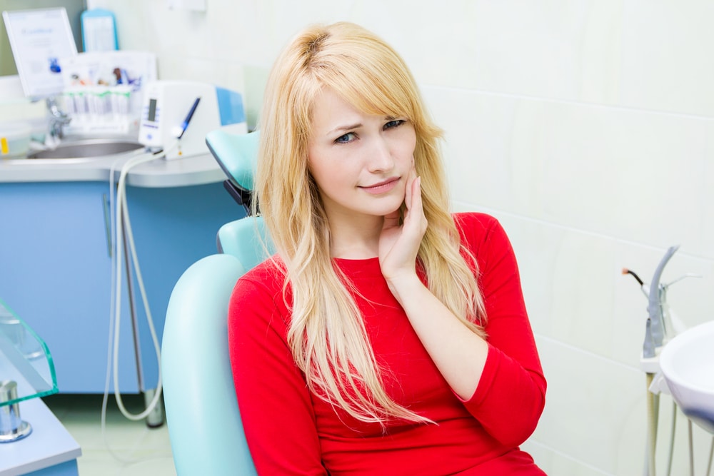 woman with blonde hair in a red shirt | Harwell & Cook Orthodontics