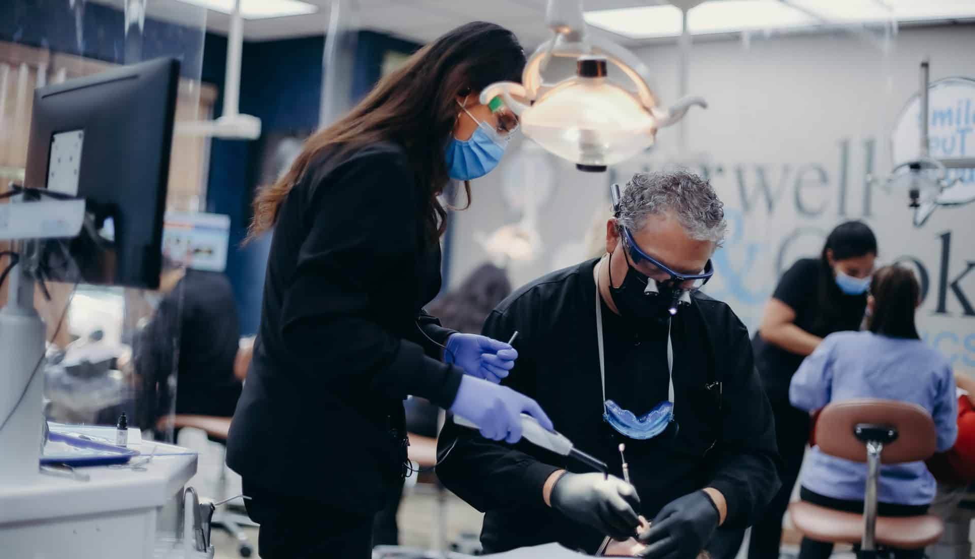Two dental professionals performing a procedure | Harwell & Cook Orthodontics
