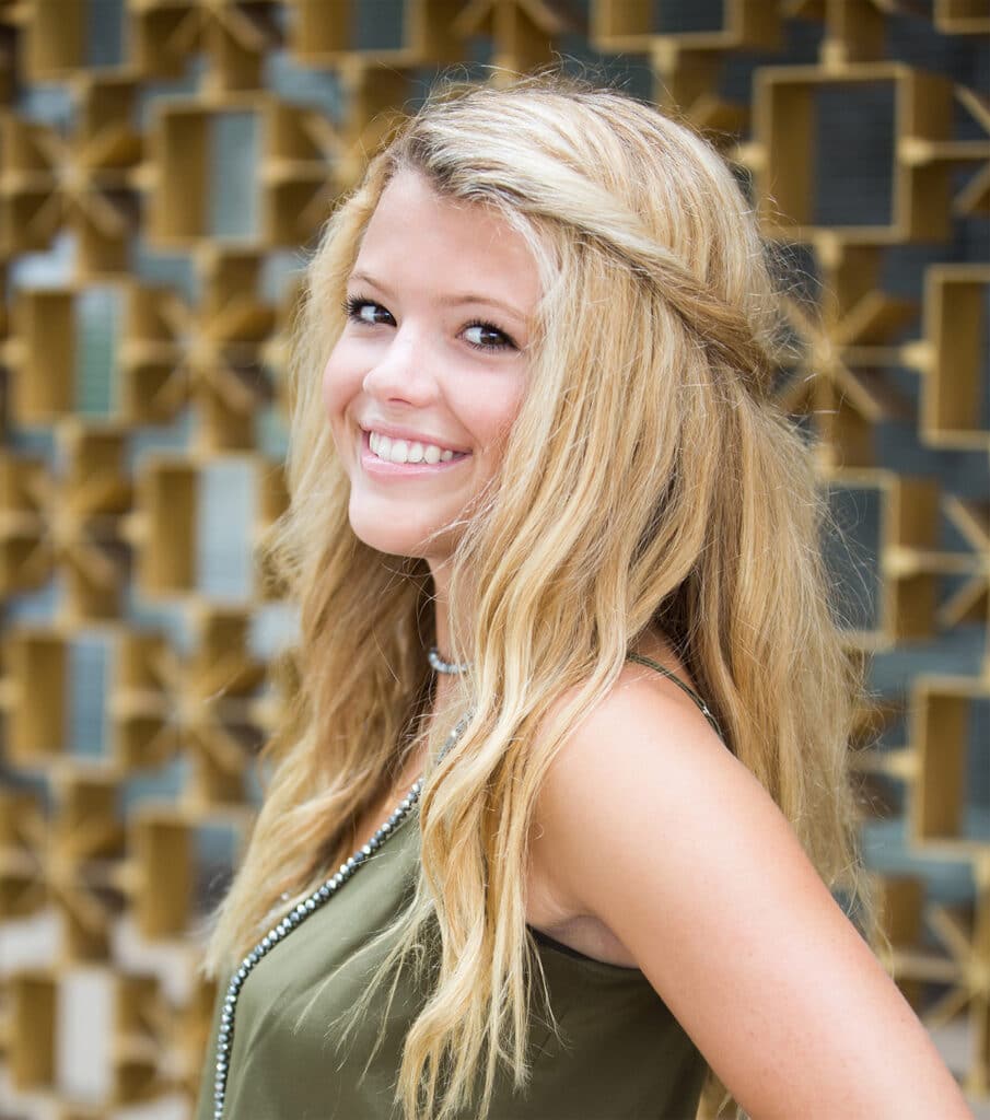 A smiling young woman with long blonde hair | Harwell & Cook Orthodontics
