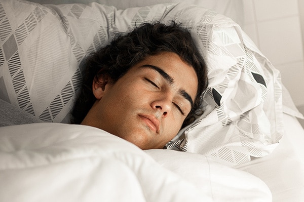 A boy resting his head on a pillow | Harwell & Cook Orthodontics