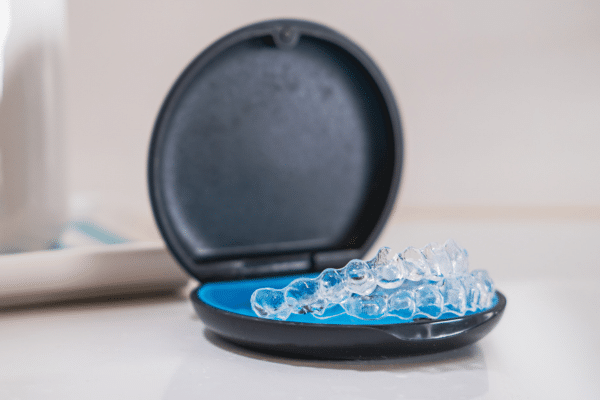 Clear dental aligners and their black carrying case | Harwell & Cook Orthodontics