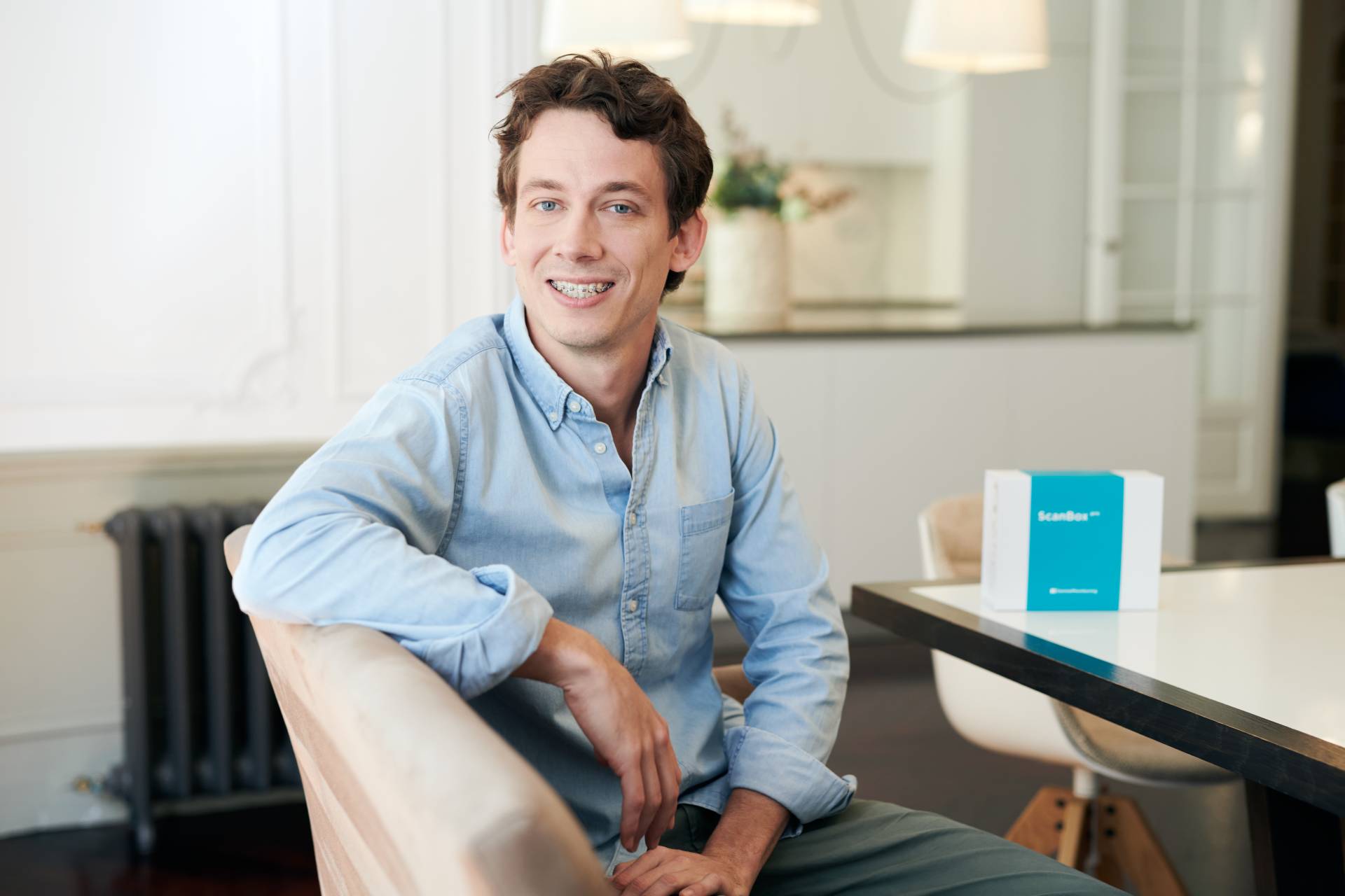 A smiling man sitting in a chair | Harwell & Cook Orthodontics