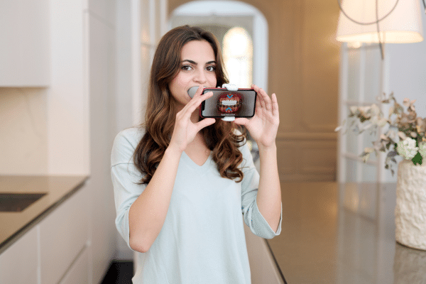 A woman using a dental monitoring device at home. | Harwell & Cook Orthodontics