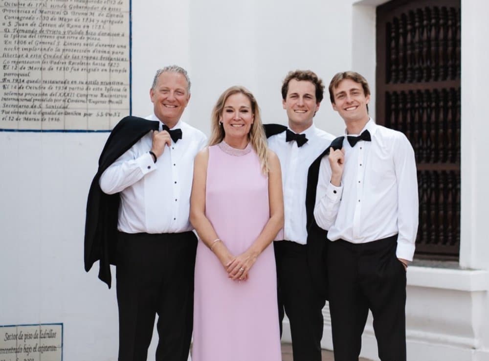 Dortors in tuxedos posing with a woman in a pink dress. | Harwell & Cook Orthodontics