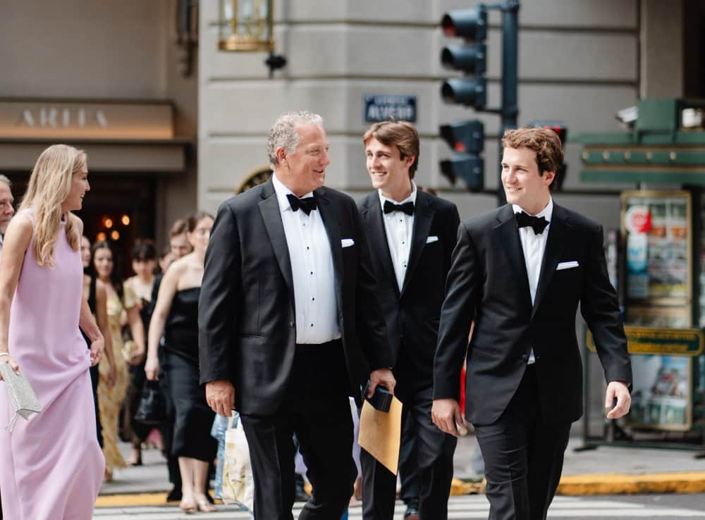 Three men in formal tuxedos walking. | Harwell & Cook Orthodontics