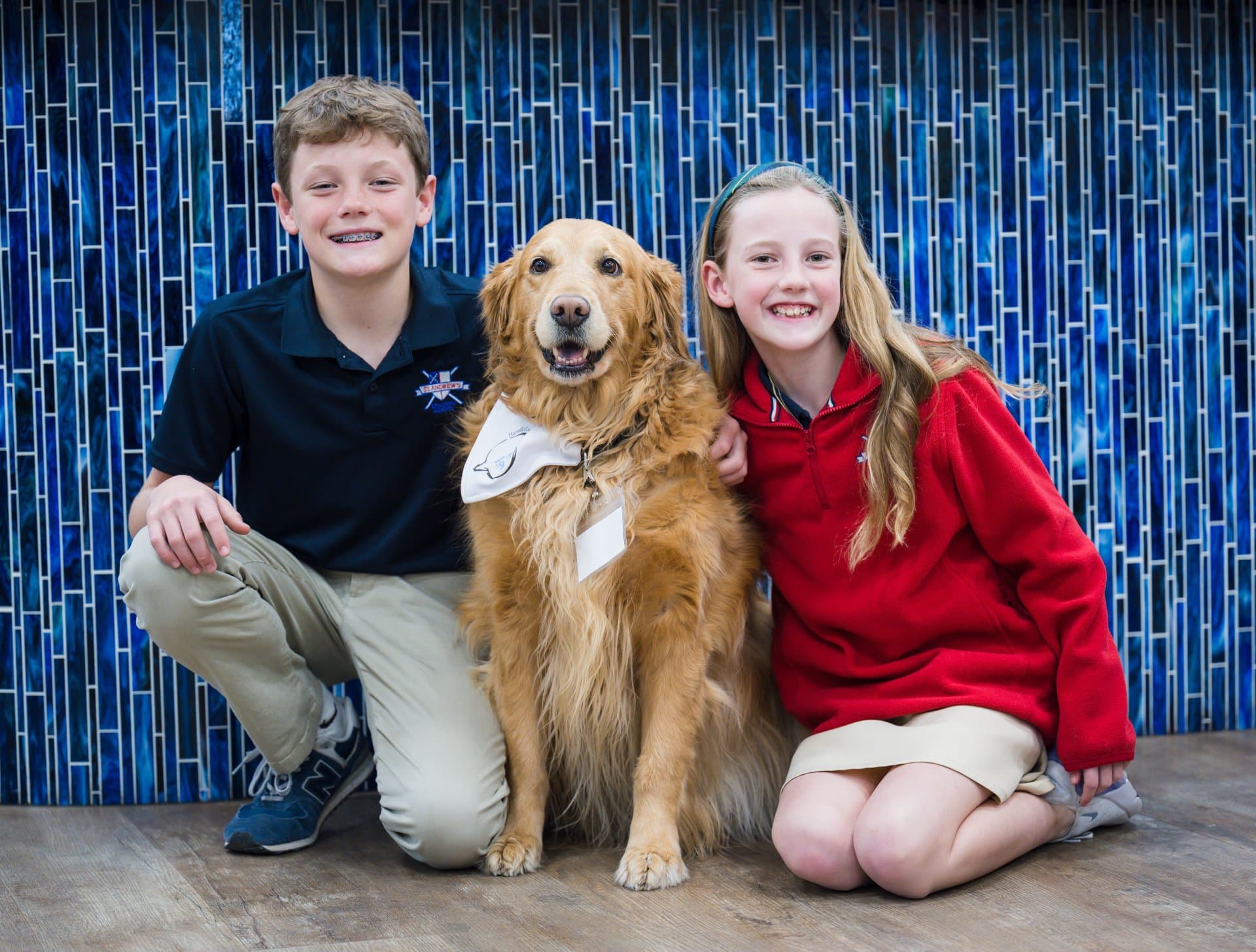 Two smiling kids and their Golden Retriever. | Harwell & Cook Orthodontics