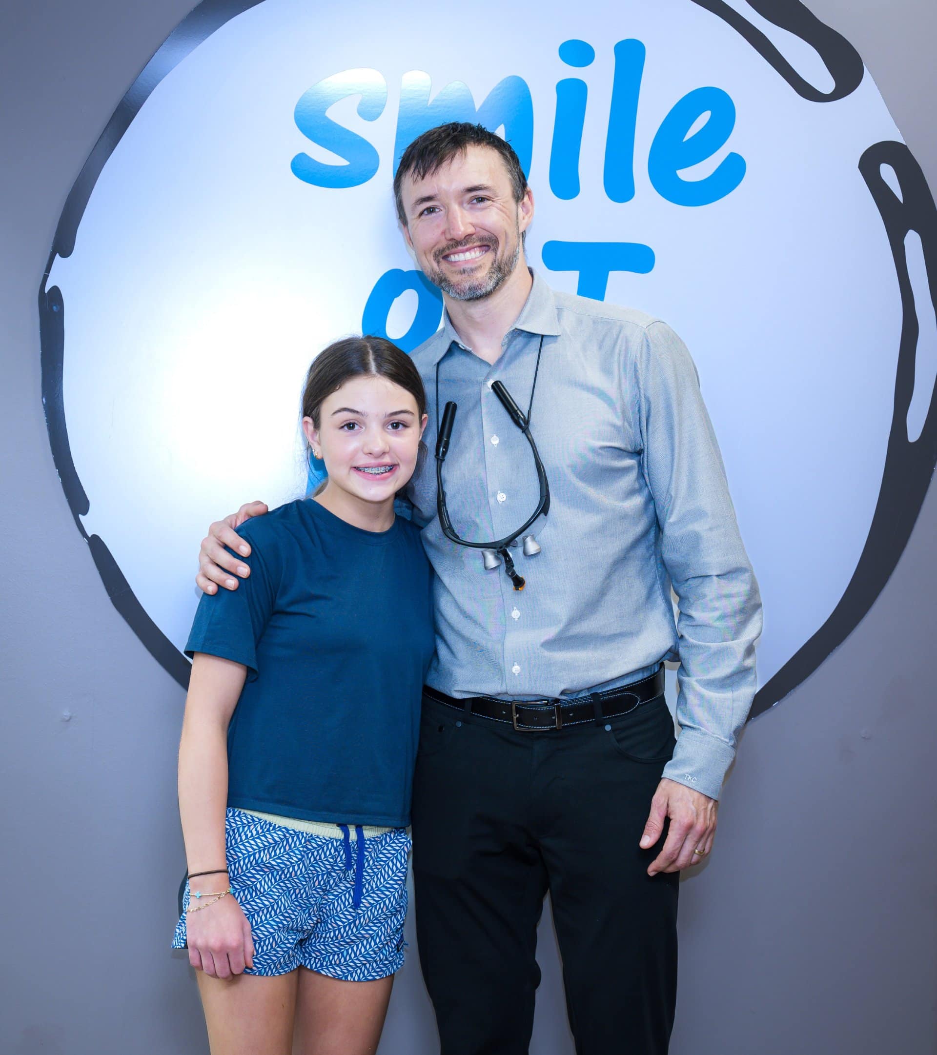 Dr Cook and a young girl posing together smiling. | Harwell & Cook Orthodontics
