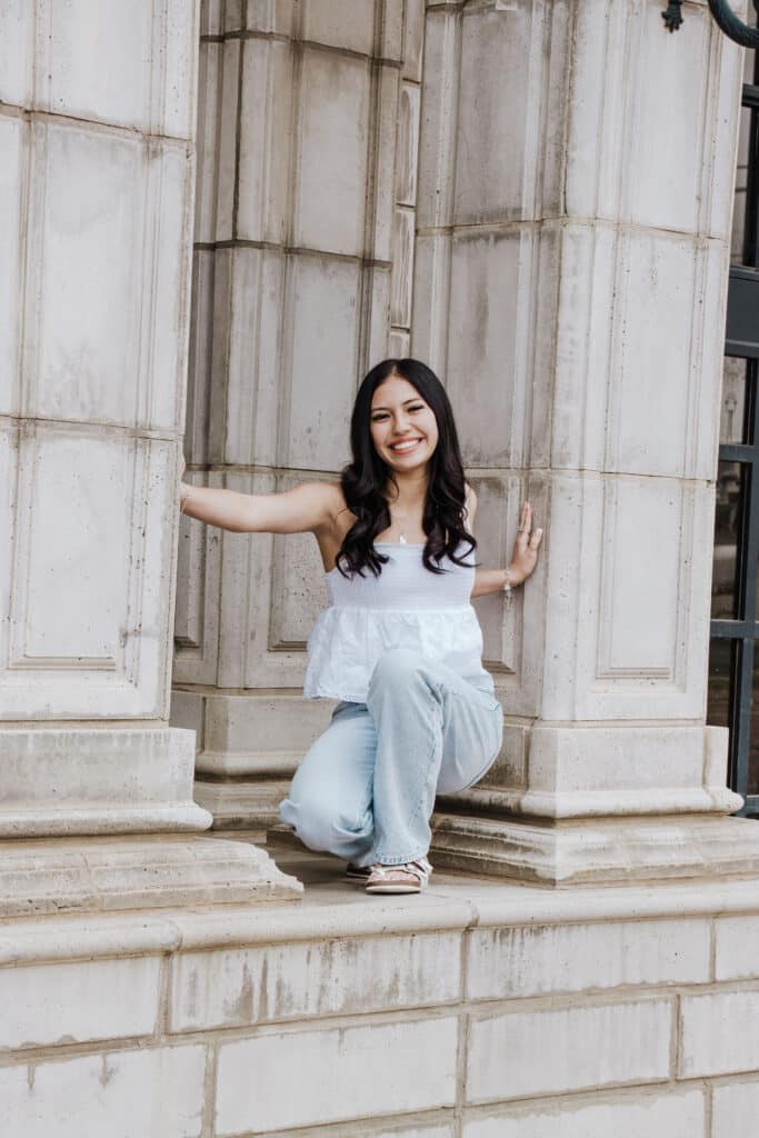 A young woman in a white top posing. | Harwell & Cook Orthodontics