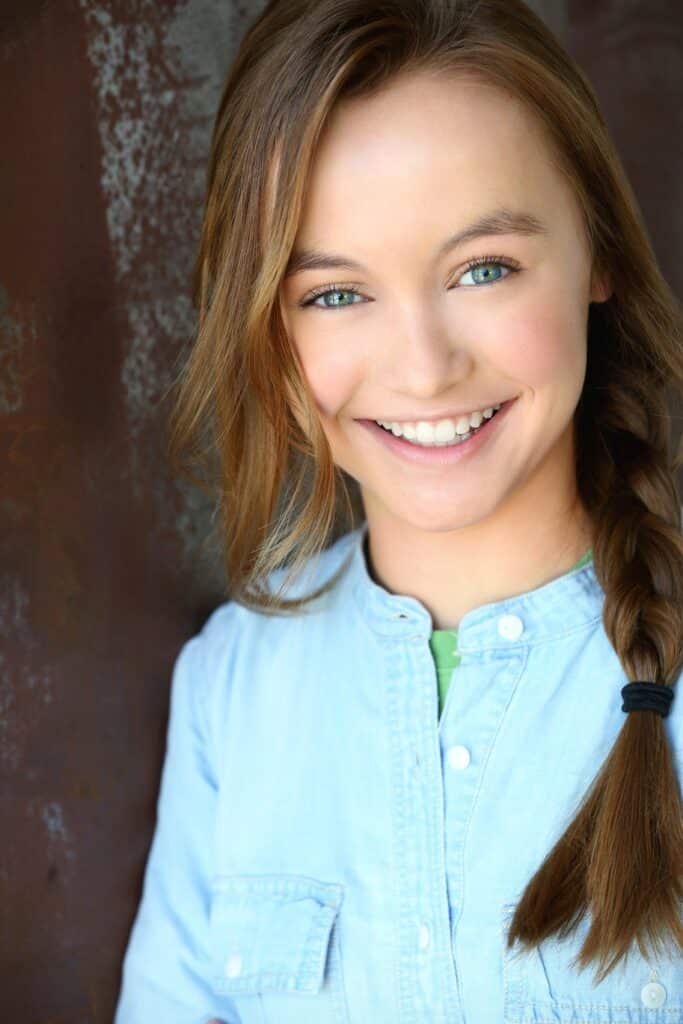 A smiling young woman in a green top. | Harwell & Cook Orthodontics